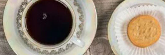 Shortbread girl scout cookie next to a teapot pouring black tea into a mug.