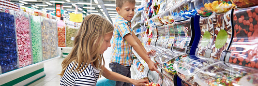 Kids scooping candy in candy store.