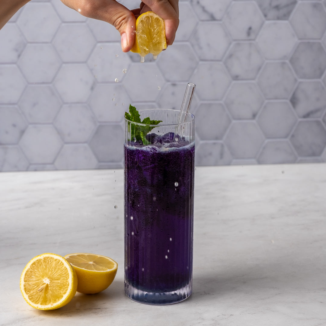 Butterfly Pea Flower Powder used to make an iced blue beverage with lemon being squeezed into it