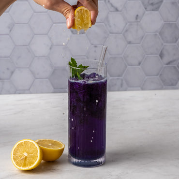 Butterfly Pea Flower Powder used to make an iced blue beverage with lemon being squeezed into it