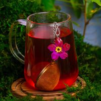 Pink Flower Charm Infuser in Steeped Tea in Glass Mug