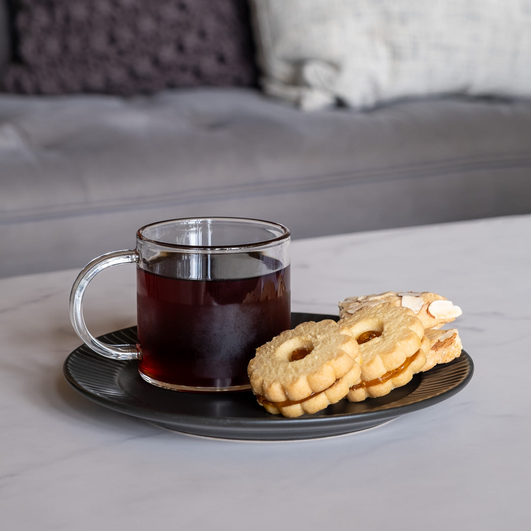 Earl Grey Black Tea brewed in clear mug on plate of cookies